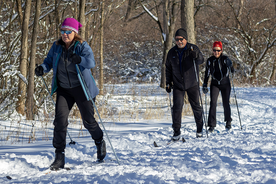 three people cross-country skiing